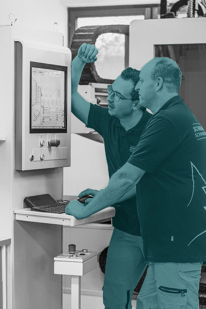 Mitarbeiter von der Schwarzwald Schreinerei bei der Arbeit an Maschinen.